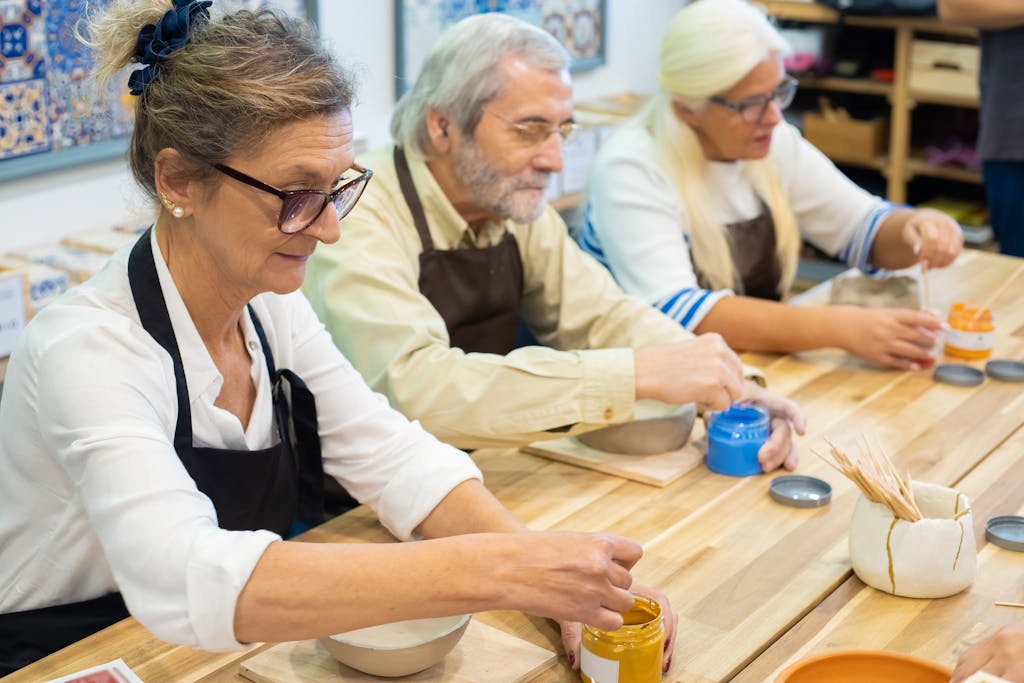 Senior adults enjoying a pottery painting workshop, showcasing creativity and craftsmanship.