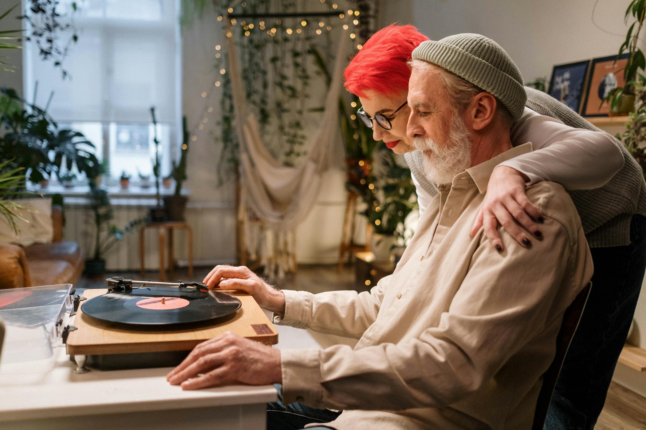 Loving couple sharing a moment listening to vinyl records in a cozy home setting.
